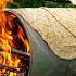 Traditional Lavash Bread Baking Bread On A Barrel Over Wood Fire